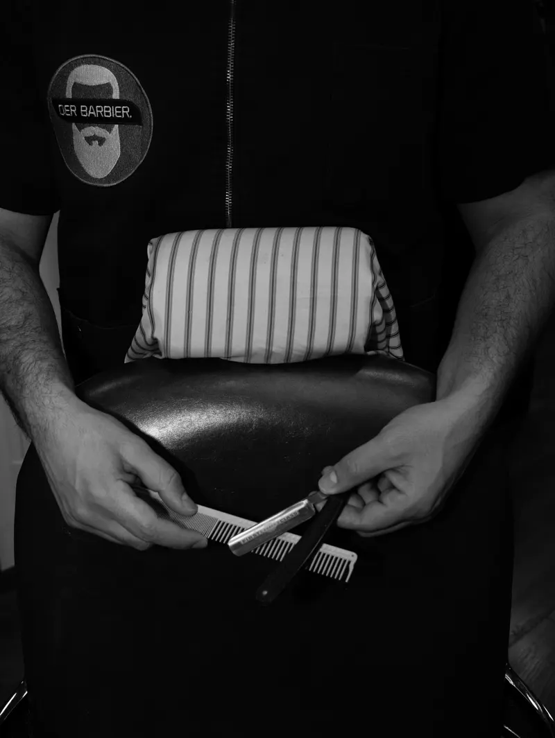 Werkzeugtasche aus Leder in den Händen des Barbiers